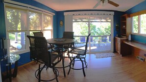 A room with a dining table and chairs, a kitchen area, and a view of the outdoors through large windows. - LAKE ACCESS & GREAT VIEWS! MINUTES TO THE WHITE RIVER!! 3 BR/2BA, 1500 sq. ft. (Bull Shoals)