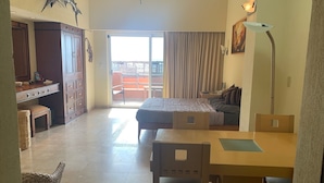 Une chambre d’hôtel avec un lit, un bureau et un balcon.