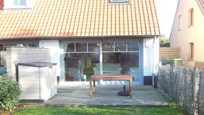 A house with a tiled roof, a fenced backyard, and a wooden table. - The Becots, family villa near beach with garden (Neufchâtel-Hardelot)