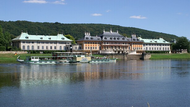 A historic building with multiple chimneys and a river in the foreground. - small cozy, lovingly furnished holiday house for 2 people (Dresden)