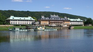 A historic building with multiple chimneys and a river in the foreground. - small cozy, lovingly furnished holiday house for 2 people (Dresden)