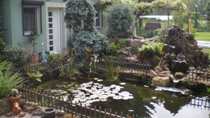 A house with a pond, surrounded by various plants and a small waterfall. - small cozy, lovingly furnished holiday house for 2 people (Dresden)