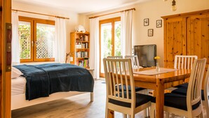 Une chambre à coucher avec un lit, un bureau en bois avec une télévision et une bibliothèque.
