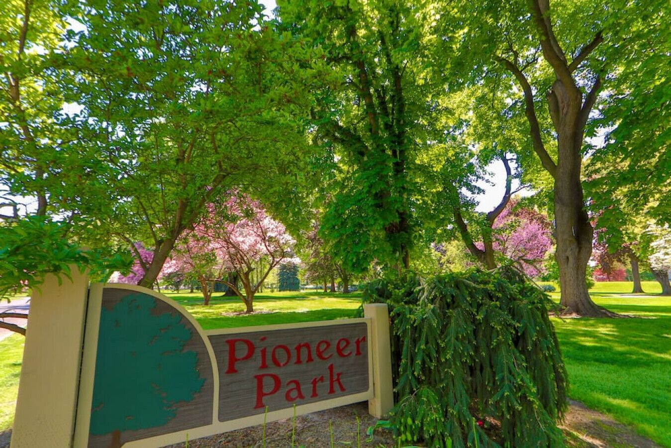 Un panneau indiquant l’entrée du parc Pioneer, entouré d’une végétation luxuriante et d’arbres.