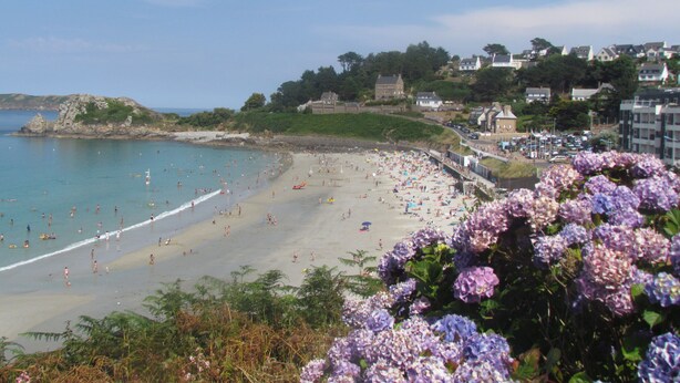 A beach with people, a clear sky, and buildings in the background. - LES PIEDS DANS L'EAU sea at 15 meters PANORAMIC VIEW PERROS GUIREC (PERROS GUIREC)