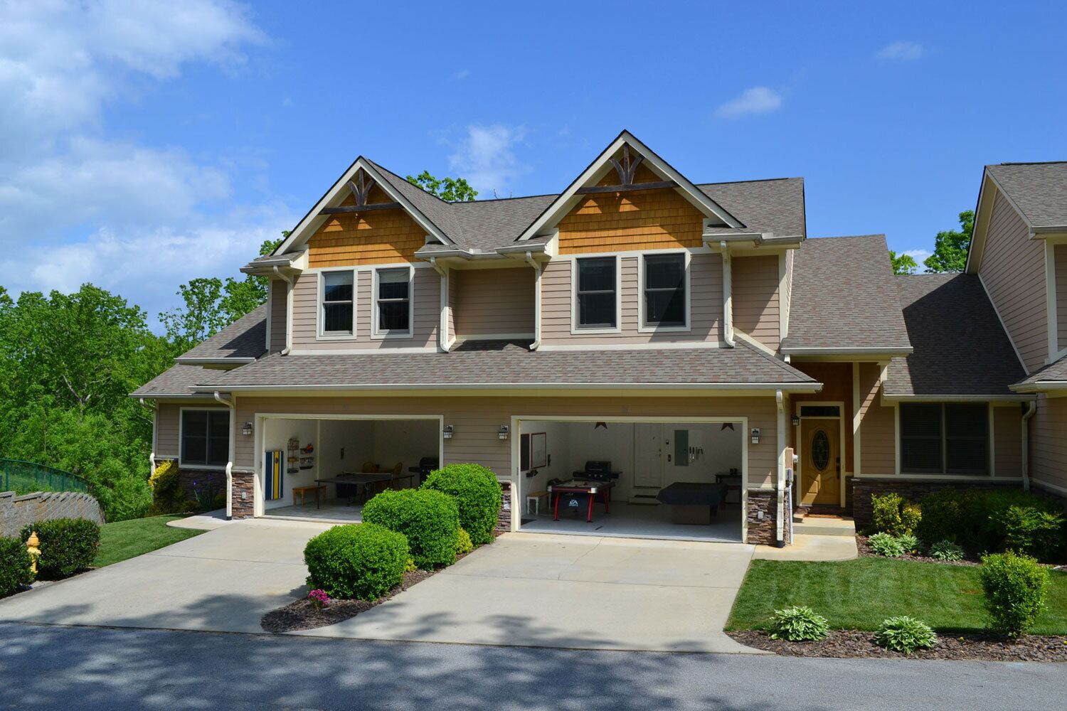 A two-story house with a covered front porch, a garage, and a landscaped front yard.