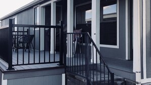 Un bâtiment moderne doté d’un porche couvert, de rampes noires et d’un escalier menant à un étage supérieur.