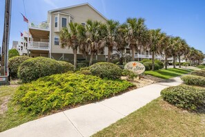 A coastal hotel with a sign reading 'Sea Star,' surrounded by well-maintained landscaping and palm trees.