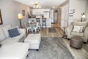 A modern living room with a sofa, ottoman, and a dining area with chairs. - 🌄Resort Vacations at Fairfield Glade TN 2 bedroom Condo with Gorgeous Lake Front (Fairfield Glade)