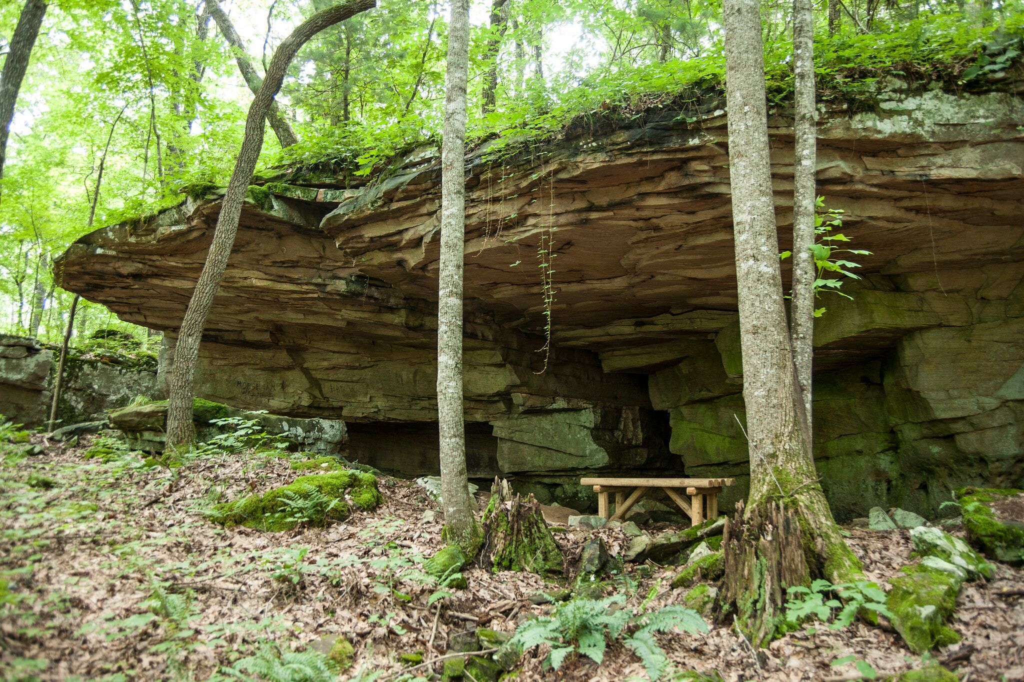 A natural rock formation with a wooden bench.