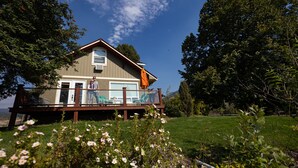 Ein Haus mit Terrasse, Garage und Rasen.