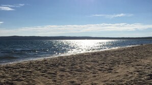 A beach with a clear sky and sunlight reflecting off the water. - Magical House in the Trees with Water View - Secluded Area (Aquinnah)