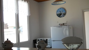 Une cuisine avec un réfrigérateur blanc, un grille-pain et une horloge au mur.