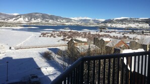 A snowy landscape with a lake, mountains, and buildings in the foreground. - On Lake Dillon with Amazing Views Everywhere! Hot Tub, Grill, Private Balcony! (Frisco)