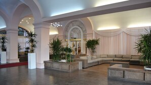 A spacious lobby with high ceilings, large columns, and a central seating area with sofas and planters. - Beach Front Resort - 2 Bedroom, 2 bathrooms, Sleeps 6, 2 Pools- at The Alexander (Miami Beach)