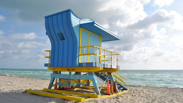 A lifeguard tower at Miami Beach with a blue and yellow color scheme, located on a sandy beach with the ocean in the background. - Beach Front Resort - 2 Bedroom, 2 bathrooms, Sleeps 6, 2 Pools- at The Alexander (Miami Beach)