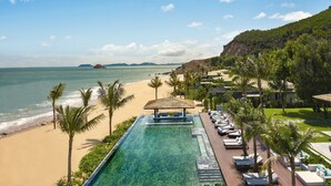 Un resort con piscina, playa y vistas al océano.