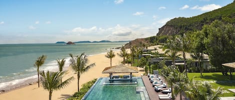 A resort with a swimming pool, beach, and ocean views.