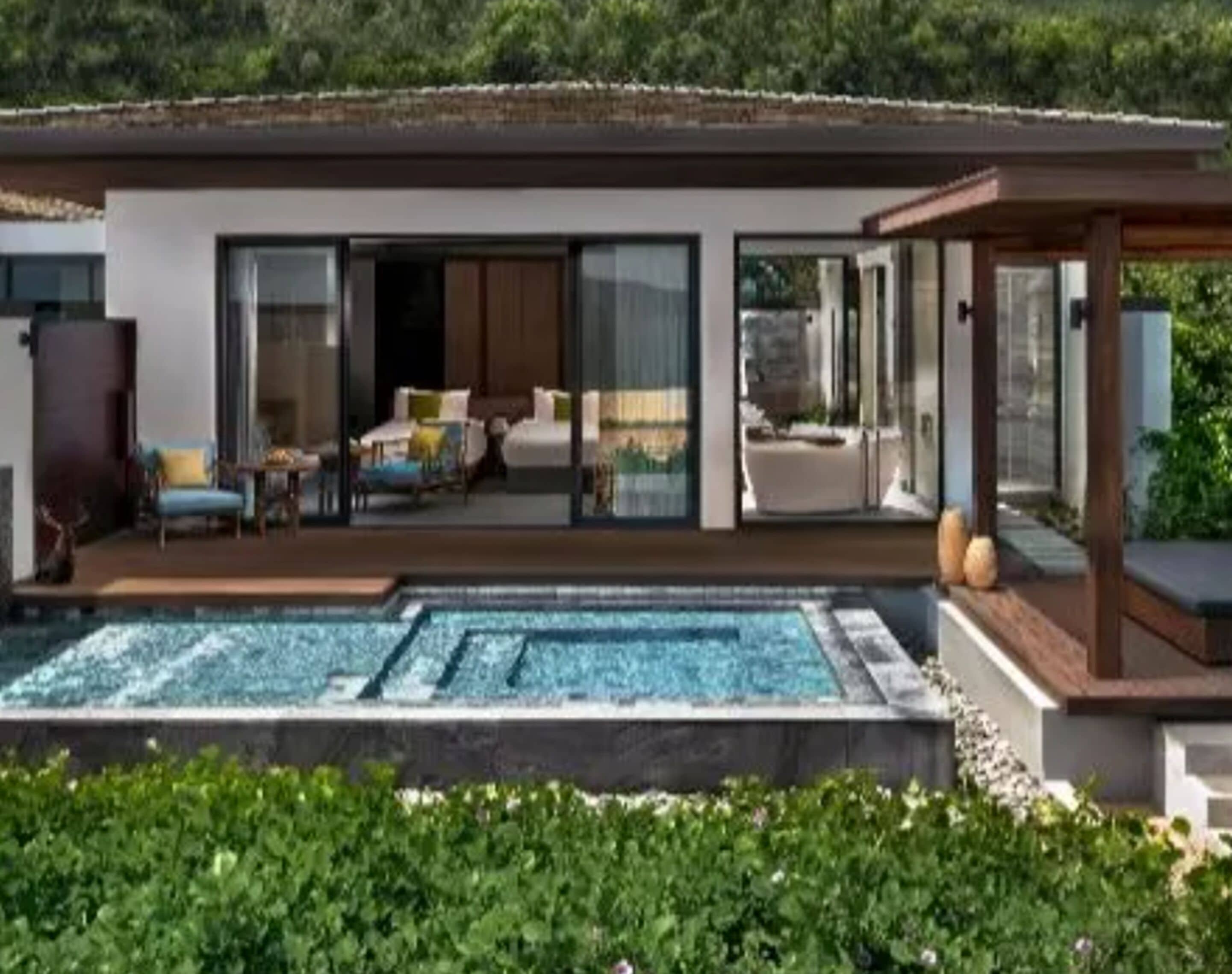 Una casa moderna con piscina, grandes puertas de vidrio y un área de patio.