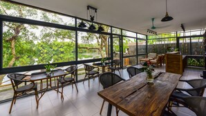 Una habitación amplia con ventanas grandes, una mesa de comedor de madera y asientos cómodos.