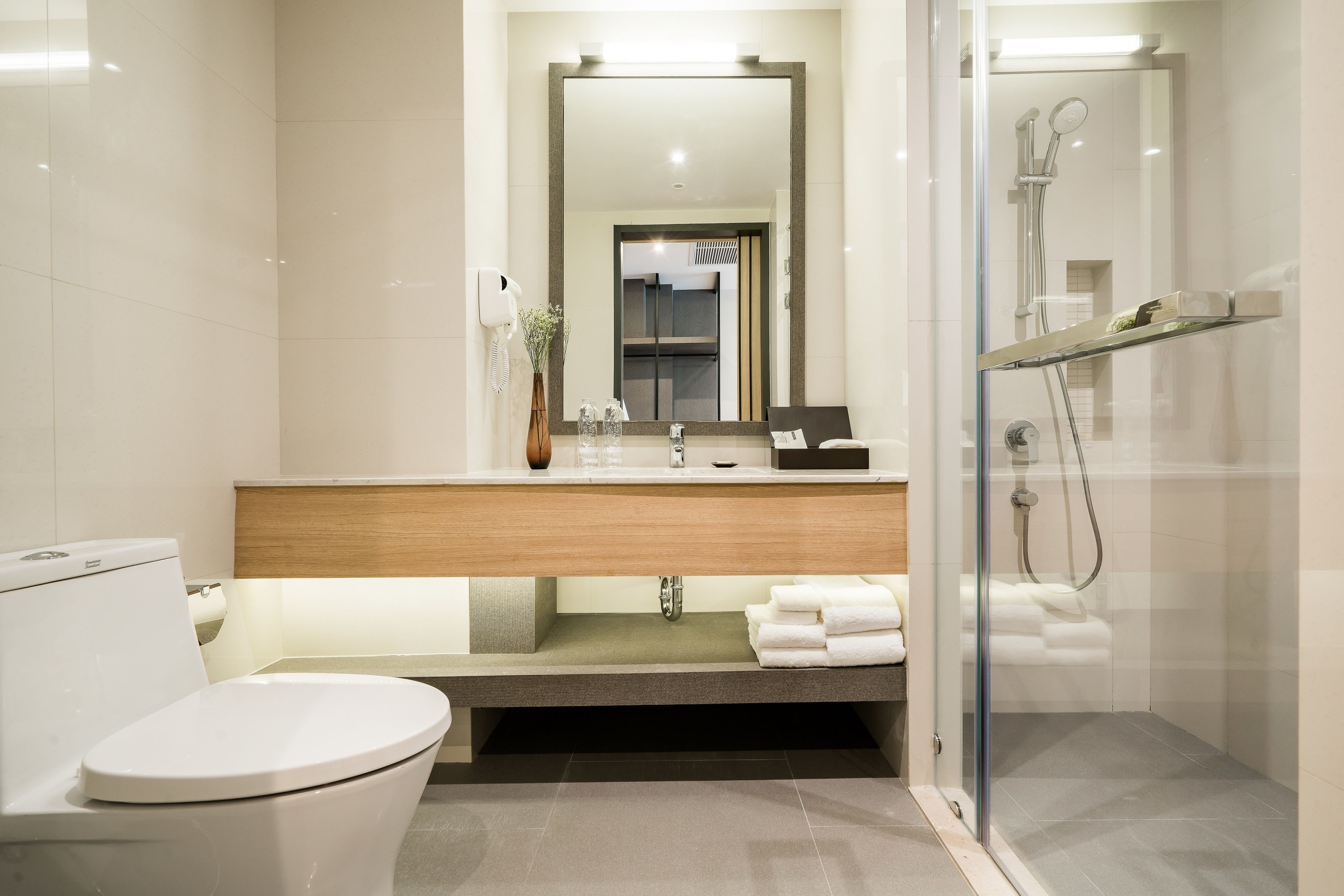 A modern bathroom with a toilet, sink, and shower.