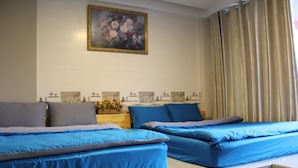 A bedroom with two beds, a painting on the wall, and a curtain. - Dalat Sky Hostel (Xuan Huong - Da Lat)