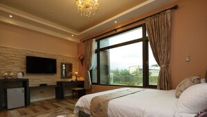A bedroom with a bed, a desk, a television, and a window with curtains. - Jifun Flower Meanings (Ji'an)