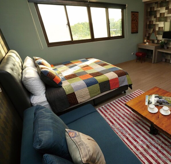 A cozy room with a bed, a sofa, a coffee table, and a desk. - Jifun Flower Meanings (Ji'an)