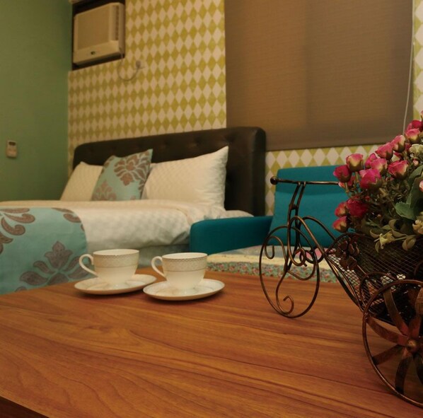 A room with a bed, a table with two cups, and a vase with flowers. - Jifun Flower Meanings (Ji'an)
