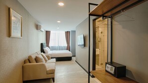 Una habitación de hotel con una cama, un sofá, un televisor y un microondas.