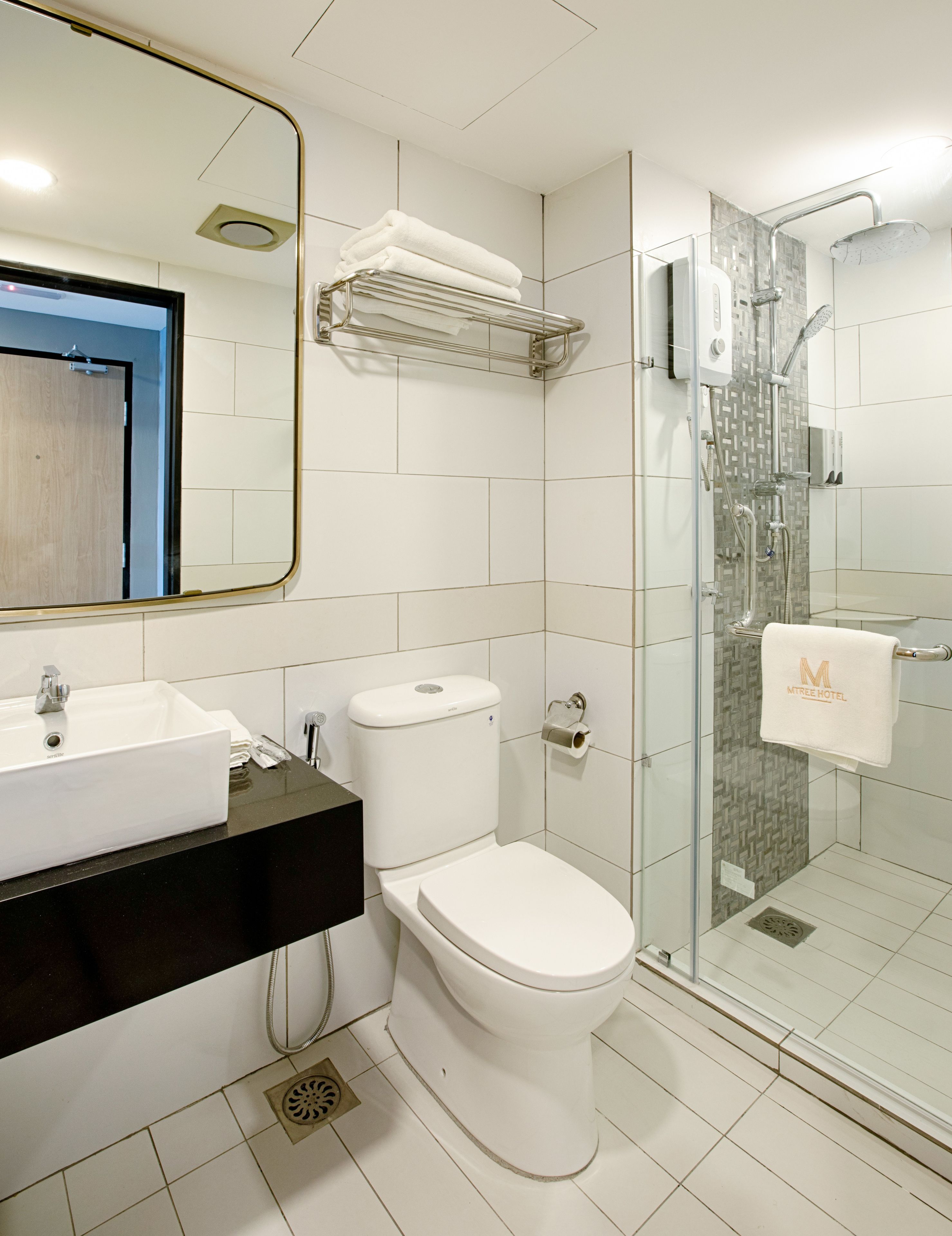 Un baño moderno con lavamanos, inodoro y ducha con cerramiento de vidrio.