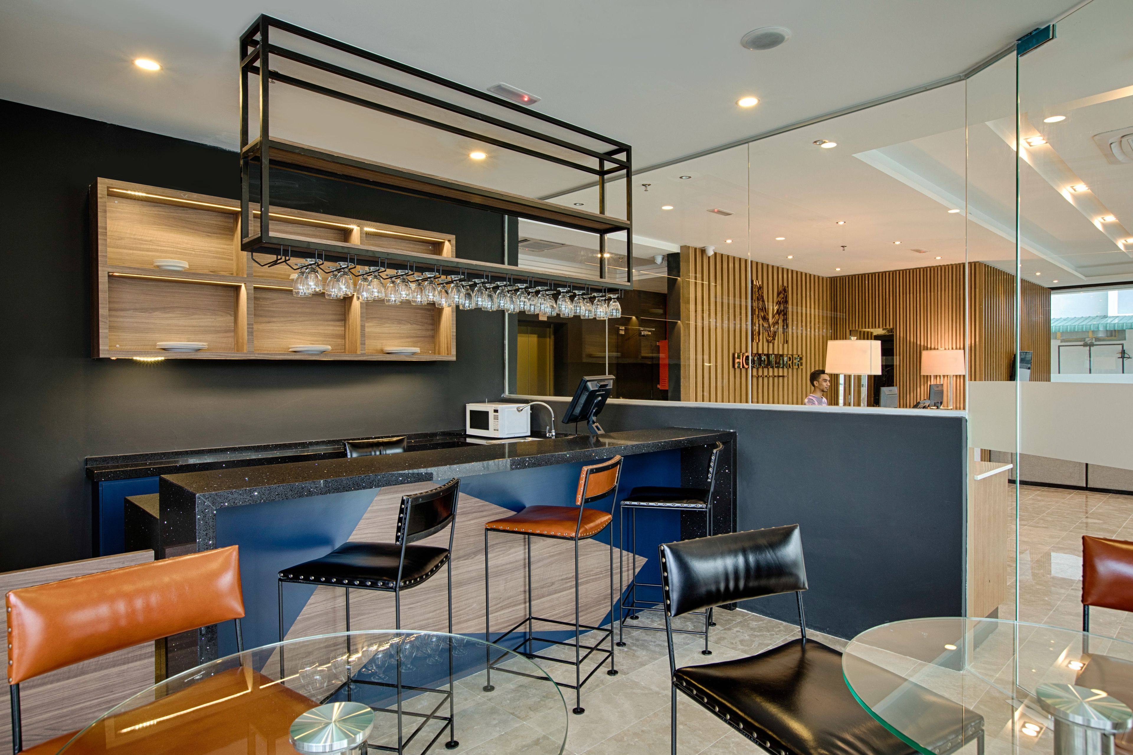 A modern hotel lobby with a bar area, seating arrangements, and a reception desk.