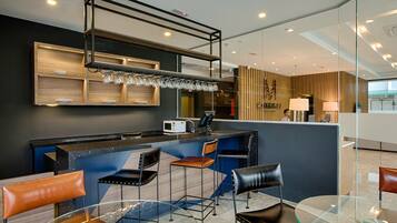 A modern hotel lobby with a bar area, seating arrangements, and a reception desk.