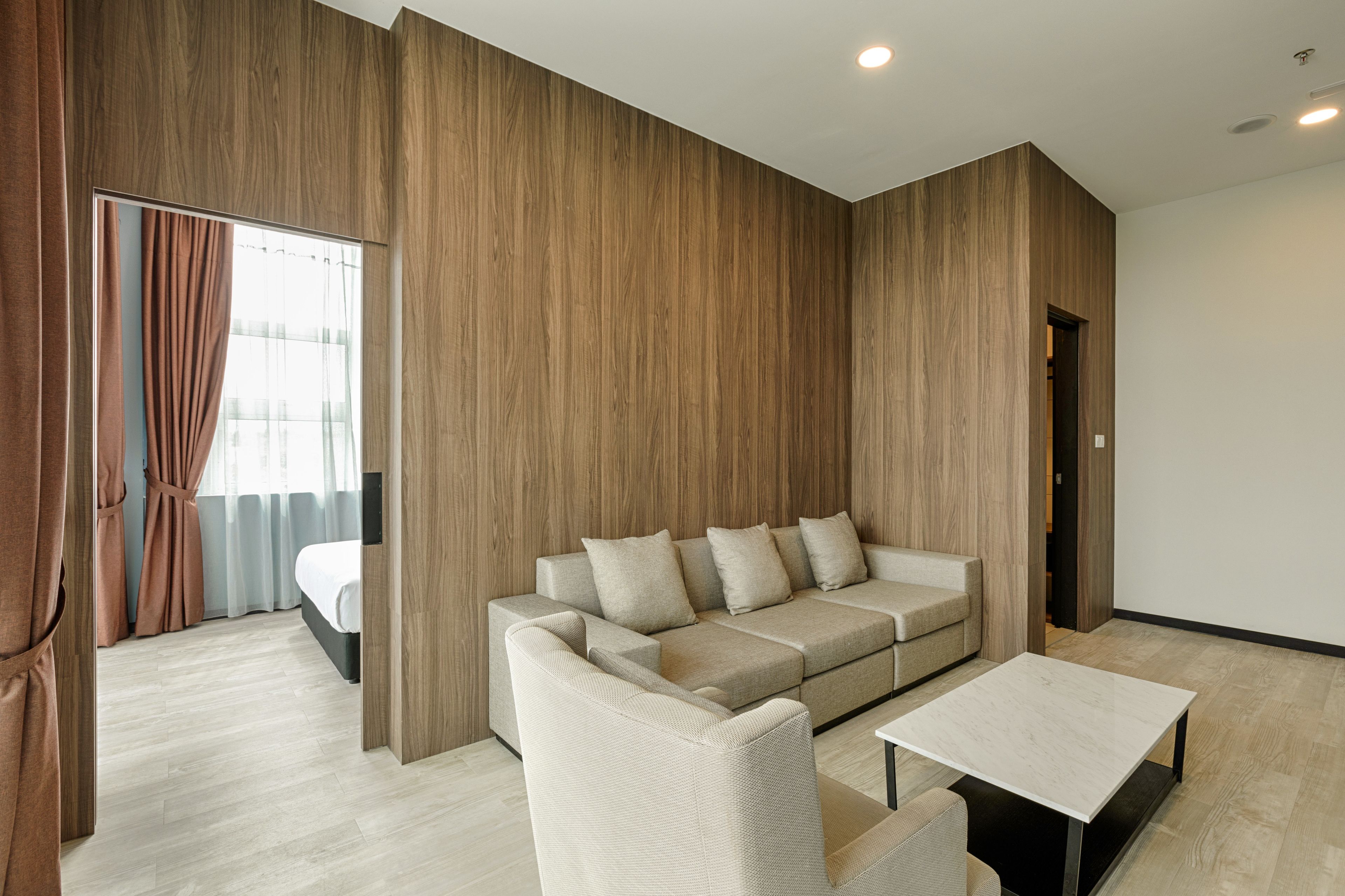 A modern living room with a sectional sofa, a small table, and a wooden accent wall.