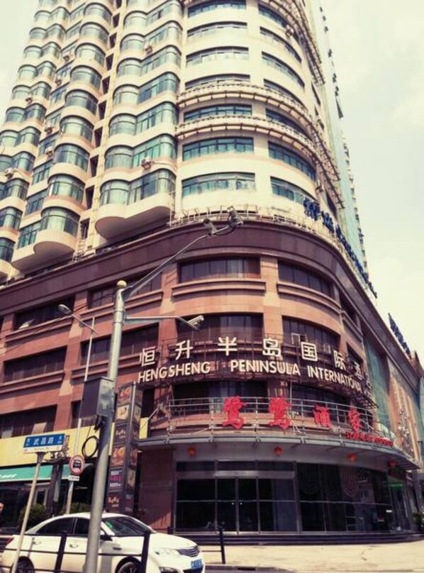 Un edificio de varios pisos con señalización para HENGSHENG PENINSULA INTERNATIONAL.
