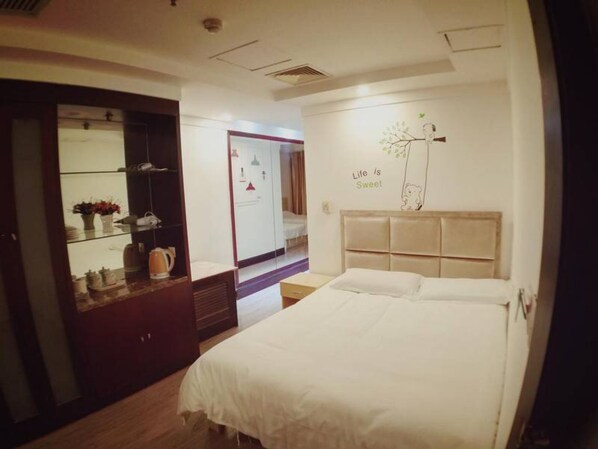Quarto de hotel com uma cama, um guarda-roupa e uma parede com uma frase motivacional.