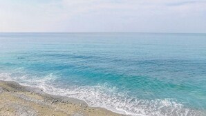 A beach with clear turquoise water and a pebbly shore. - Nice apartment in Acciaroli with house sea view (Acciaroli)