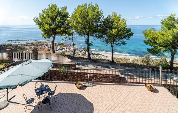 Un patio con mobiliario exterior y vista al mar.