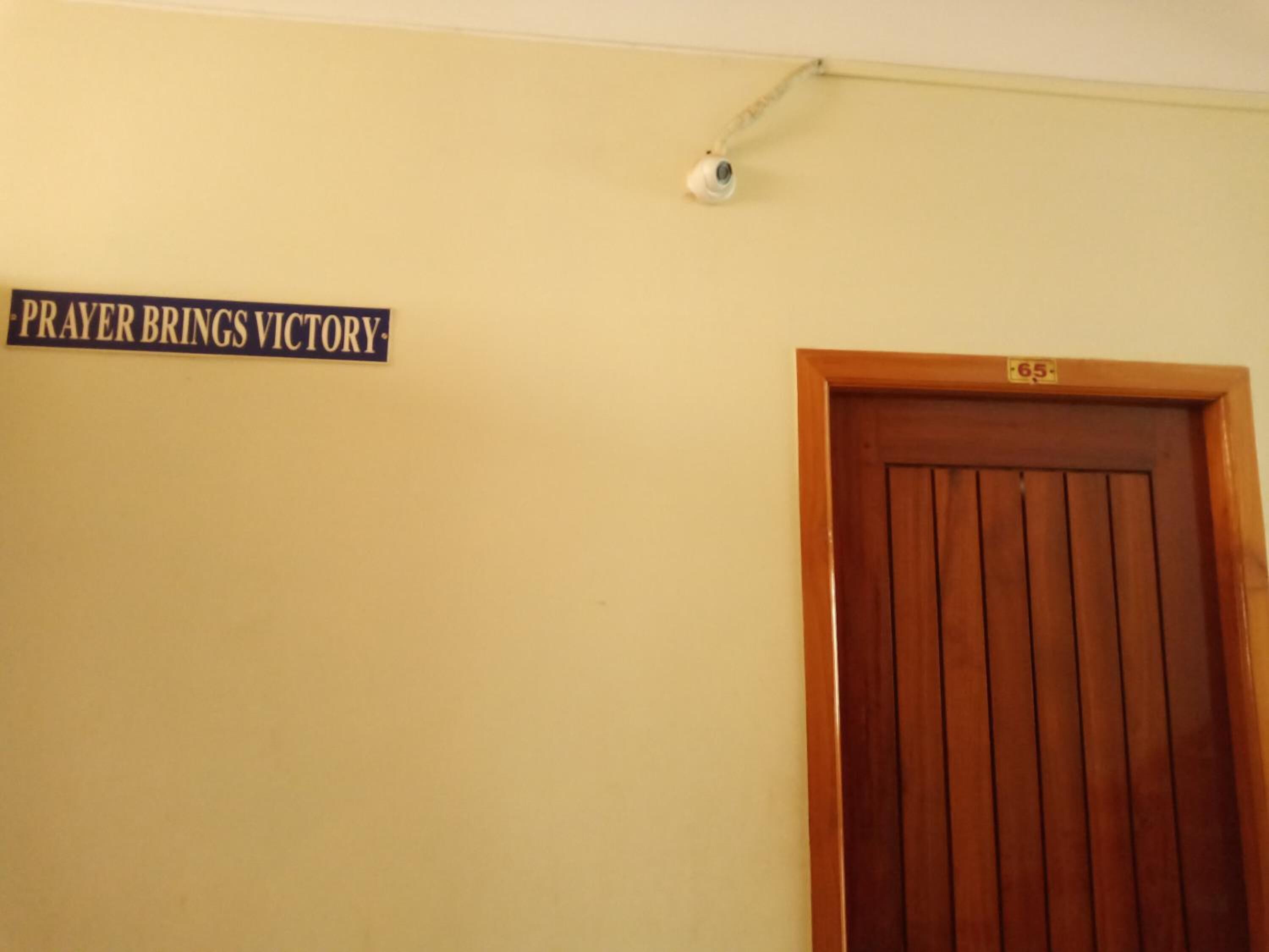 Una puerta con un letrero encima que dice "PRAYER BRINGS VICTORY".