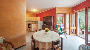 A cozy interior with a dining table, chairs, a kitchen area, and a sliding glass door leading to an outdoor space. - Beach front apartment in Porto Alabe (Porto Alabe)