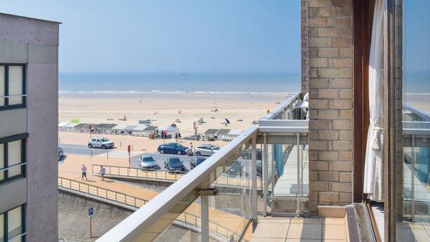 A balcony with a view of a beach and parking area. - Residentie De Kateie ref 15 (Ooostende)