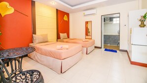 A hotel room with two beds, a small table, and a mirror. - Huandalha Resort Lumphun (Lamphun)