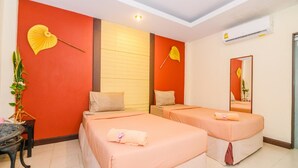 A hotel room with two beds, a potted plant, a small table, and a mirror. - Huandalha Resort Lumphun (Lamphun)