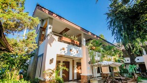 A two-story building with a balcony, potted plants, and outdoor seating. - Huandalha Resort Lumphun (Lamphun)