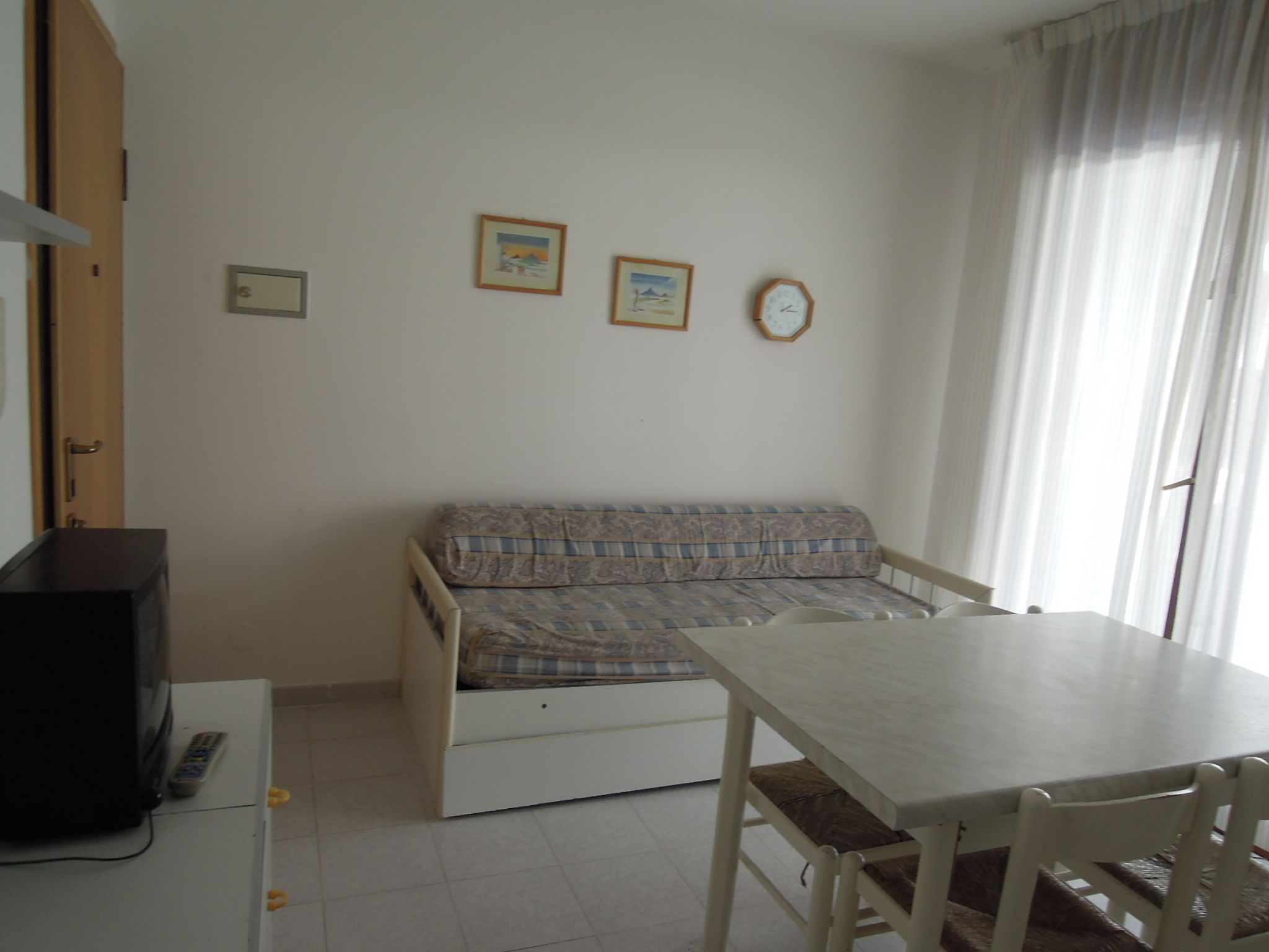 A small room with a sofa, a table, and a TV.