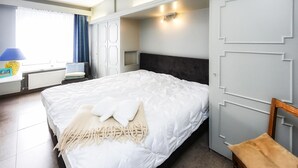 A bedroom with a bed, a desk, a chair, a wardrobe, and a window with curtains. - Costa Brava 3e Ref. Nr 202 (Oostende)