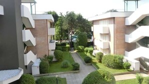 A modern apartment complex with multiple buildings, a central courtyard with greenery, and a clear sky. - Residence Gemini (San Michele al Tagliamento)
