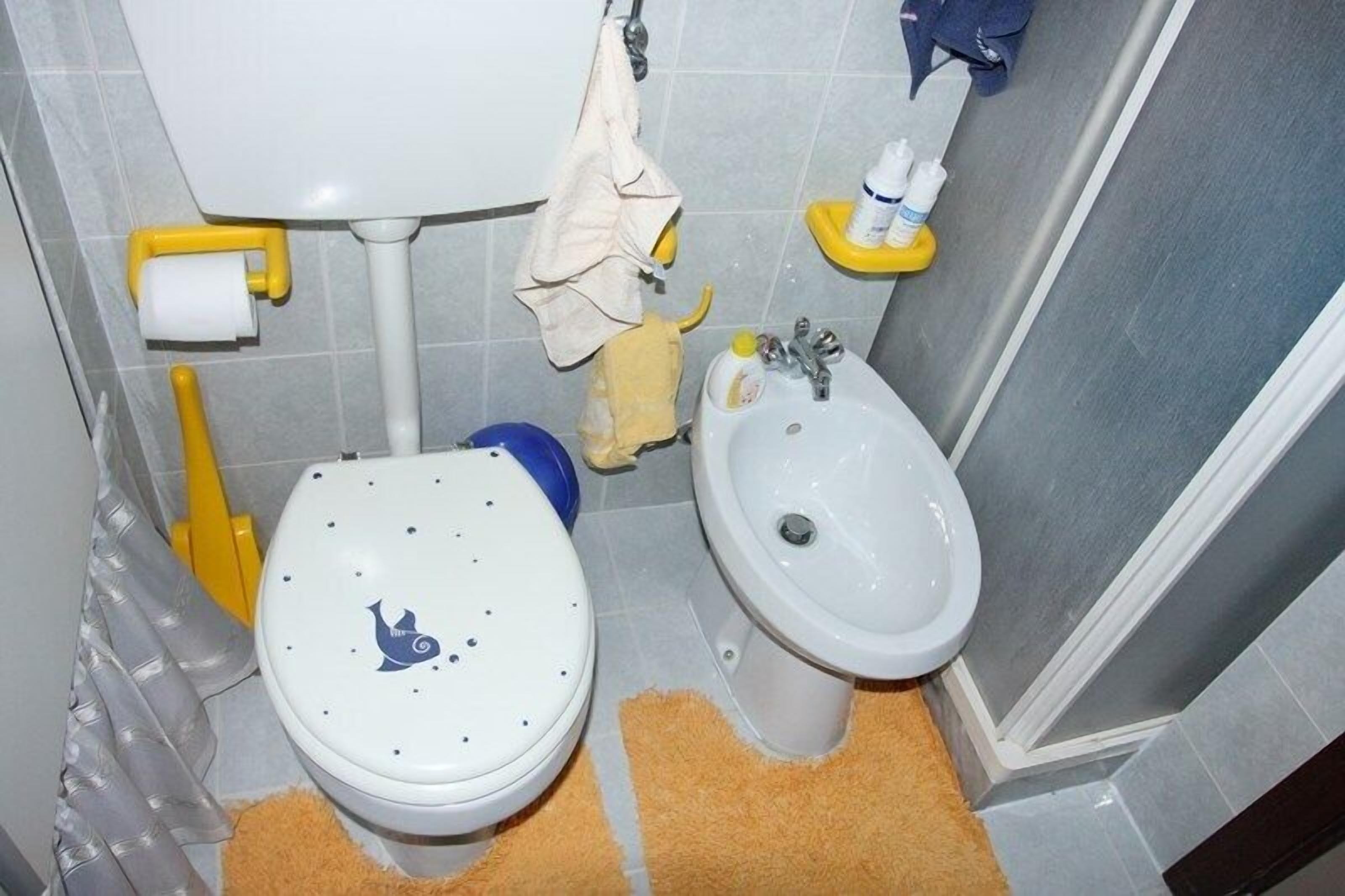 A bathroom with a toilet, bidet, and sink.