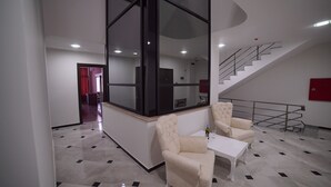Un salon moderne avec une grande fenêtre, un escalier et un coin repas.