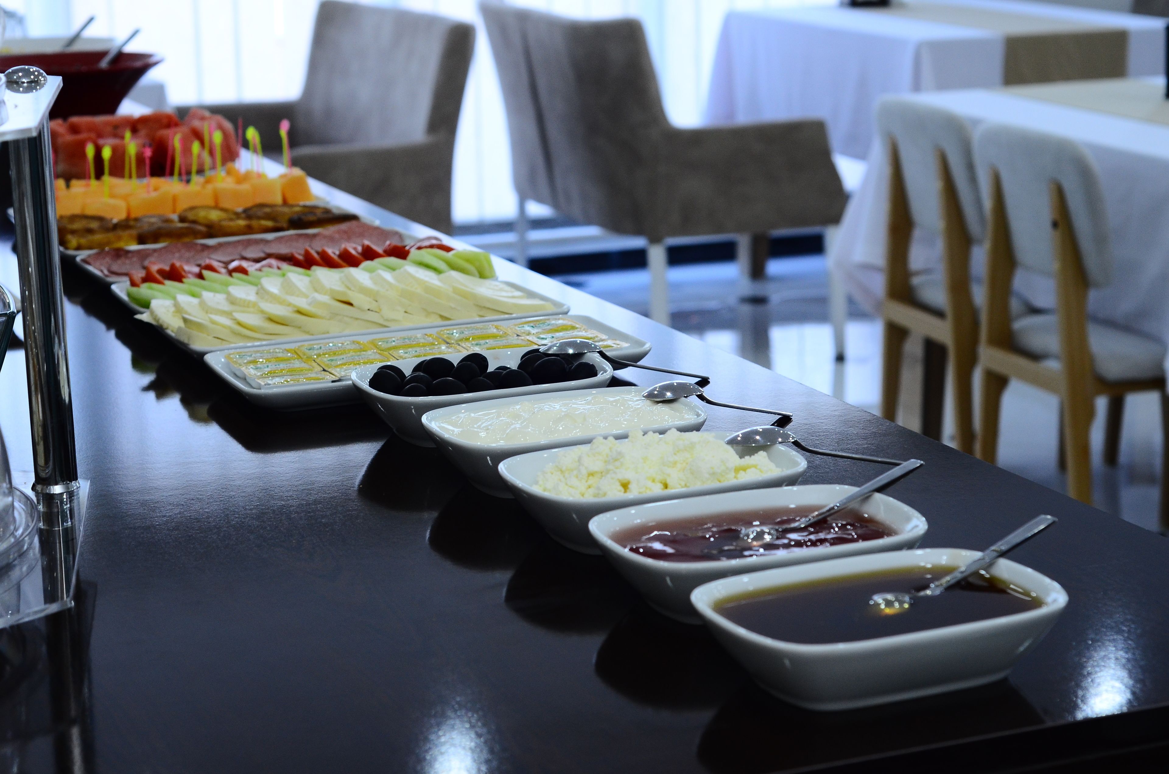 A buffet table with various food items and condiments.